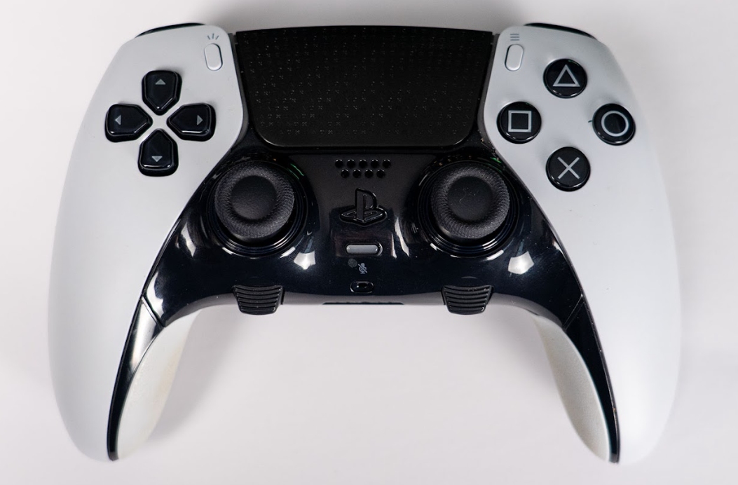 A white and black DualSense Edge controller photographed from above on a pale background.