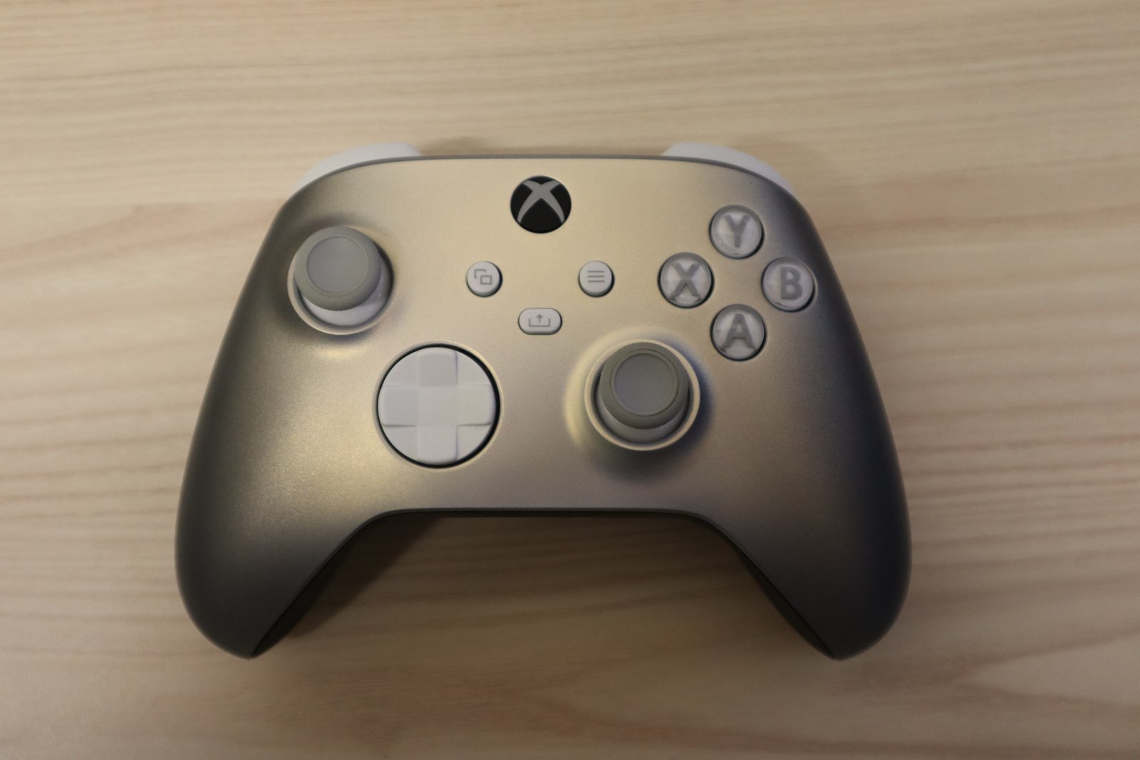 A silver Lunar Shift Xbox Wireless Controller photographed from above on a wooden surface.